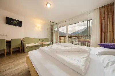 a hotel room with two beds and a balcony at Mounthotel Niggl in Nova Levante