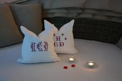 two pillows with chinese writing on them on a bed with candles at Hotel Garnì Carpe Diem in Vigo di Fassa