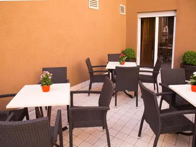 a restaurant with tables and chairs with flowers on them at Hotel Regina in Bolzano
