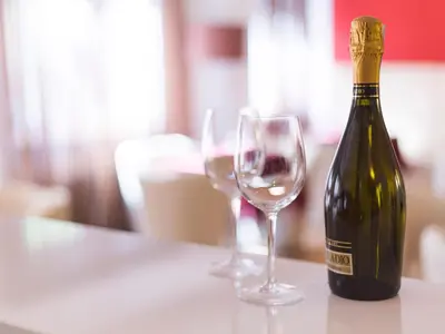 a bottle of wine and two wine glasses on a table at Hotel Regina in Bolzano
