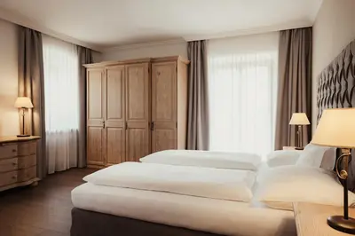 a bedroom with two beds and a large window at Kristallhotel Corona-Krone in San Vigilio Di Marebbe