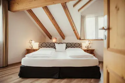 a bedroom with a large bed in a attic at Kristallhotel Corona-Krone in San Vigilio Di Marebbe