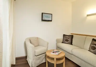 a living room with a couch and a chair and a table at Hotel Leitner in Mühlbach