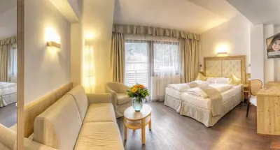 a hotel room with a bed and a couch at Hotel Leitner in Mühlbach