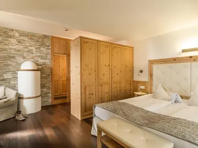 a bedroom with a large bed and wooden walls at Hotel Leitner in Mühlbach