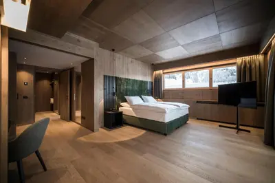 a bedroom with a bed and a television in it at Hotel Cappella in Colfosco