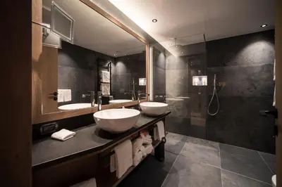a bathroom with two sinks and a shower at Hotel Cappella in Colfosco