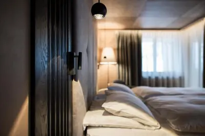 a bedroom with a bed with pillows and a window at Hotel Cappella in Colfosco