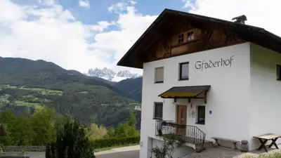 a building with a view of mountains at Agriturismo Gfaderhof in Bressanone