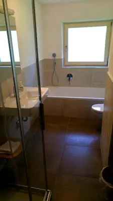 a bathroom with a tub and a sink and a toilet at Agriturismo Gfaderhof in Bressanone