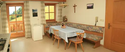 a kitchen with a table and chairs and a couch at Agriturismo Gfaderhof in Bressanone