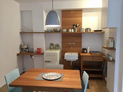 a dining room with a table and a kitchen at M-Loft merangardenvilla in Merano