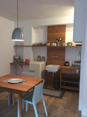 a kitchen with a wooden table and a table and chairs at M-Loft merangardenvilla in Merano