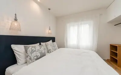 a bedroom with a white bed and a window at M-Loft merangardenvilla in Merano