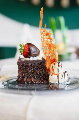 a piece of chocolate cake with a strawberry on top at Olimpionico Hotel in Castello di Fiemme