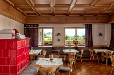 a restaurant with tables and chairs and windows at Hotel Alla Rocca in Varena