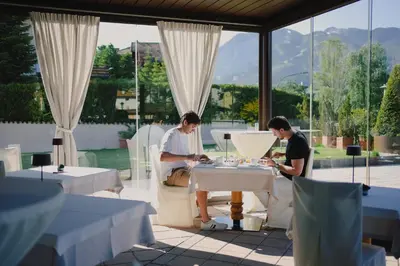 two people sitting at a table in a restaurant at Hotel Bellavista in Cavalese