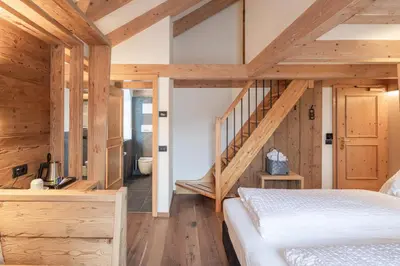 a bedroom with a staircase in a wooden house at Hotel Bellavista in Cavalese