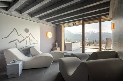 a living room with couches and a view of mountains at Hotel Bellavista in Cavalese