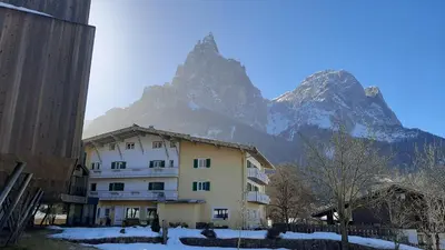 a building with a mountain in the background at Parc Hotel Florian in Siusi