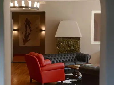 a living room with a couch and a chair at Family Hotel Gran Baita in Pozza di Fassa