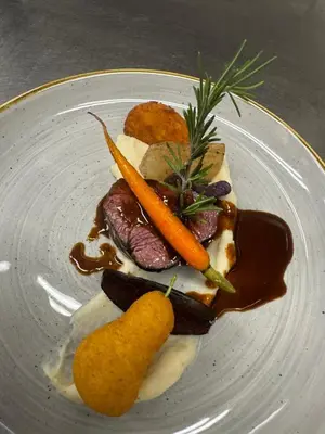 a plate of food with carrots and meat and gravy at Hotel Post - Olang in Valdaora