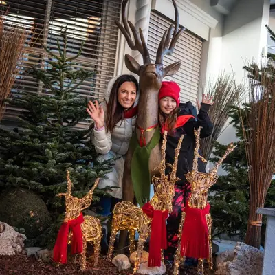 a family posing in front of a christmas display at Hotel Post - Olang in Valdaora