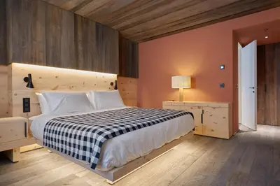 a bedroom with a bed with a black and white checkered blanket at HOTEL de LEN in Cortina dʼAmpezzo