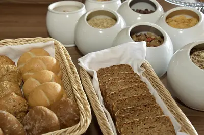 a table topped with baskets of bread and other foods at Hotel Walder in Schenna