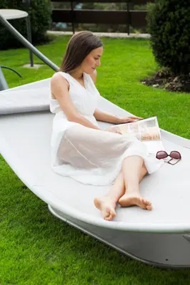 a woman in a white dress sitting on a hammock at Hotel Walder in Schenna