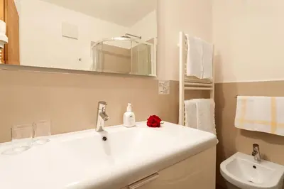 a white bathroom with a sink and a toilet at Hotel Walder in Schenna