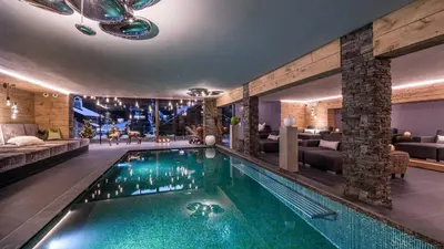 a pool in the middle of a room with a living room at Alpin Garden Luxury Maison & SPA - Adults Retreat in Ortisei
