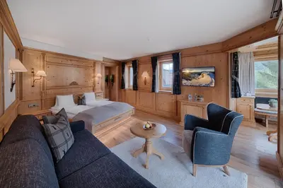 a bedroom with a large bed and a balcony at Majestic - Unique Spa Resort in Brunico