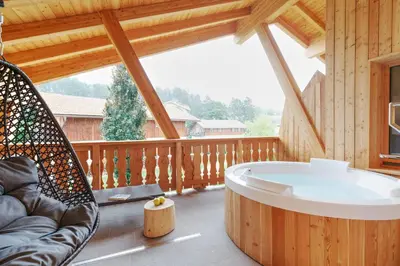 a large porch with a hot tub in a cabin at Pineta Nature Resort - Wellness & SPA in Coredo