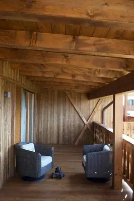 a living room with two chairs and a wooden ceiling at Pineta Nature Resort - Wellness & SPA in Coredo