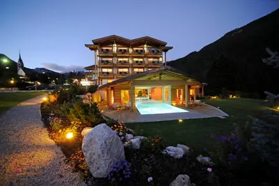 a large building with a pool in a yard at Olympic SPA Hotel - Adults Only in Vigo di Fassa