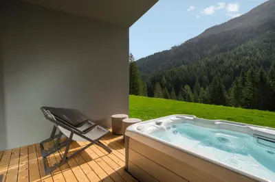 a jacuzzi tub with a view of a mountain at Olympic SPA Hotel - Adults Only in Vigo di Fassa