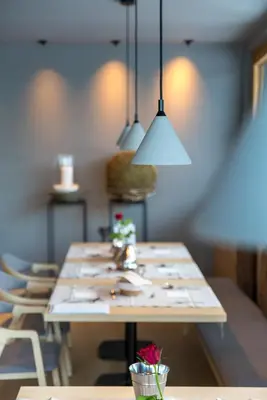 a long table in a room with chairs and lights at Olympic SPA Hotel - Adults Only in Vigo di Fassa