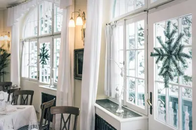 a dining room with a christmas tree in a window at Parkhotel Holzner in Soprabolzano