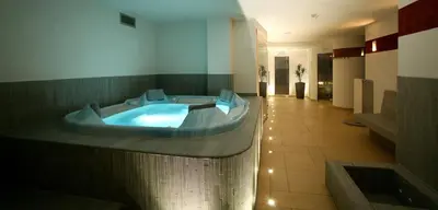 a bathroom with a tub in the middle of a room at Hotel Ladinia in La Villa