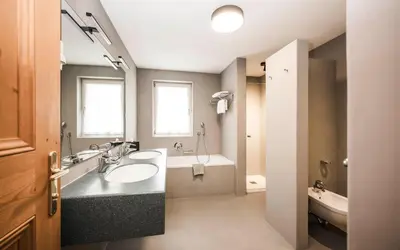 a bathroom with two sinks and a bath tub at Hotel Ladinia in La Villa