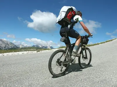a man riding a bike down a road at Moar's Hotel in Valdaora
