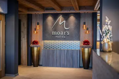 a lobby with a mars hotel sign on the wall at Moar's Hotel in Valdaora