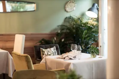 a dining room with two tables with wine glasses at Boutique Hotel Zum Rosenbaum in Nalles