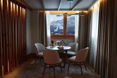 a dining room with a table and chairs and a window at Grand Hotel Savoia Cortina d'Ampezzo, A Radisson Collection Hotel in Cortina dʼAmpezzo