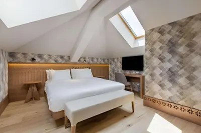 a bedroom with a bed and a skylight at Grand Hotel Savoia Cortina d'Ampezzo, A Radisson Collection Hotel in Cortina dʼAmpezzo