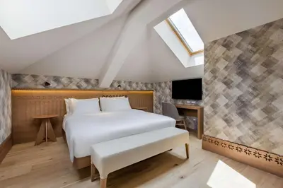 a bedroom with a bed and a skylight at Grand Hotel Savoia Cortina d'Ampezzo, A Radisson Collection Hotel in Cortina dʼAmpezzo