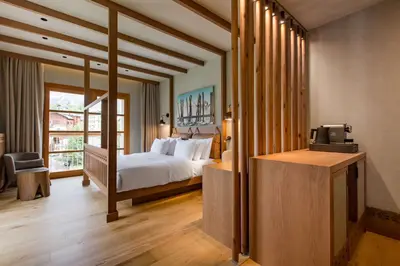 a bedroom with a bed and a tv in a room at Grand Hotel Savoia Cortina d'Ampezzo, A Radisson Collection Hotel in Cortina dʼAmpezzo