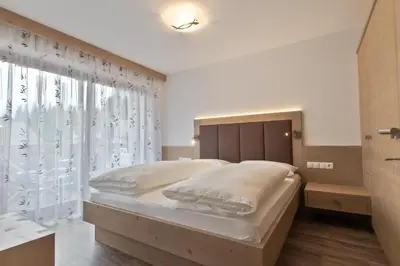 a bedroom with a large bed and a window at Apartments Ciasa Costa in Badia