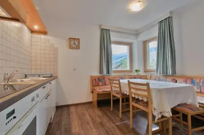a kitchen with a table and chairs and a sink at Apartments Ciasa Costa in Badia